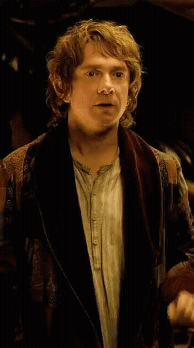 A Man With Curly Hair Is Wearing A Brown Jacket GIF