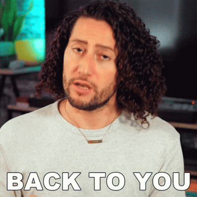 A Man With Curly Hair Is Wearing A Necklace And Says Back To You GIF
