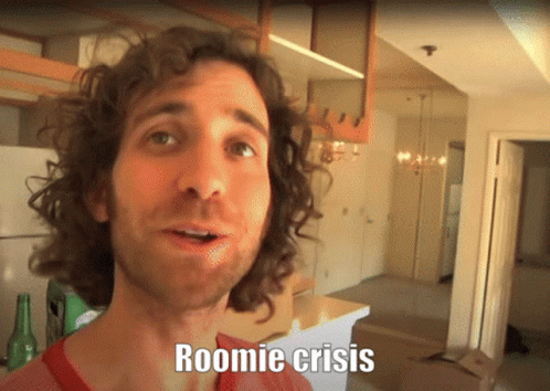 A Man With Curly Hair Says Roomie Crisis In Front Of An Empty Kitchen GIF