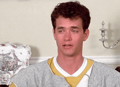 A Man With Curly Hair Wearing A Grey Sweater And A Yellow Sweatshirt GIF