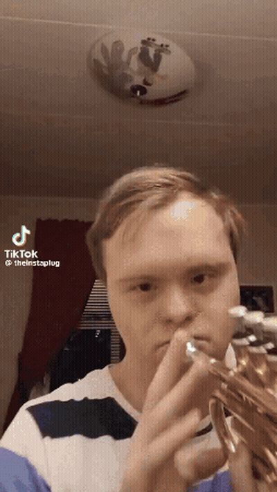 A Man With Down Syndrome Is Playing A Trumpet In A Tiktok GIF