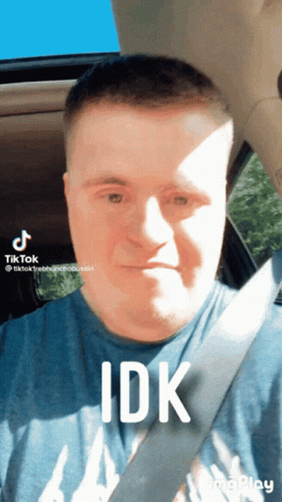 A Man With Down Syndrome Is Wearing A Blue Shirt And A Seat Belt GIF