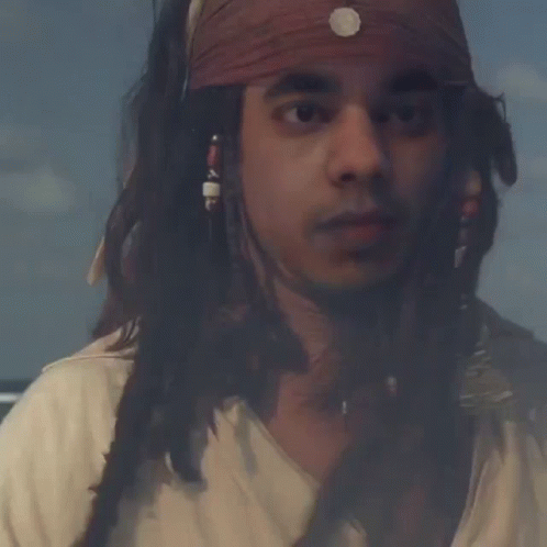 Man With Dreadlocks And Bandana Looking At Camera GIF