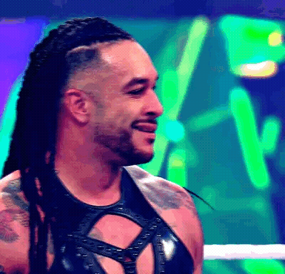 A Man With Dreadlocks And A Beard Is Smiling In A Boxing Ring . GIF