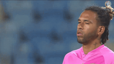 A Man With Dreadlocks And A Cross Tattoo On His Neck Is Wearing A Pink Shirt GIF