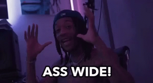 A Man With Dreadlocks And A Hat Is Saying Ass Wide GIF