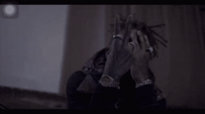 A Man With Dreadlocks And A Ring On His Finger Is Making A Peace Sign . GIF