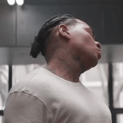 A Man With Dreadlocks And A Tattoo On His Neck Is Looking Down GIF