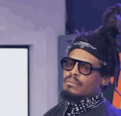 A Man With Dreadlocks And Glasses Is Wearing A Headband And A Bandana . GIF