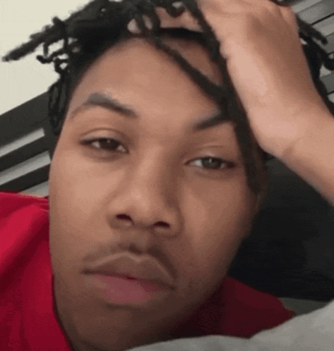 A Man With Dreadlocks Has His Hand On His Head Making A Funny Face GIF