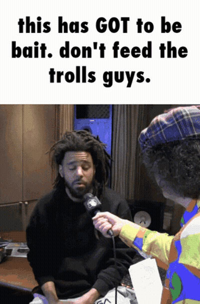 A Man With Dreadlocks Is Being Interviewed By A Man In A Clown Hat GIF