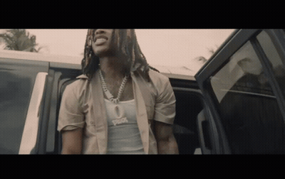 A Man With Dreadlocks Is Getting Out Of A Car And Wearing A Tank Top That Says ' Rick ' On It GIF