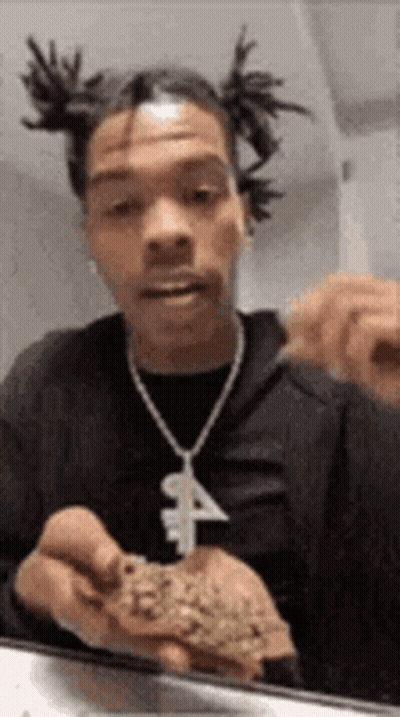 A Man With Dreadlocks Is Holding A Piece Of Marijuana In His Hands . GIF
