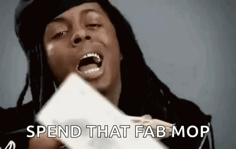 A Man With Dreadlocks Is Holding A Piece Of Paper With His Mouth Open And Says `` Spend That Fab Mop '' . GIF