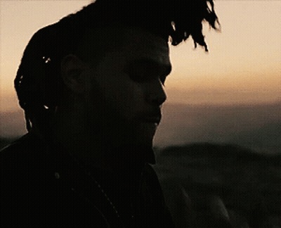 A Man With Dreadlocks Is Looking At A Cell Phone GIF