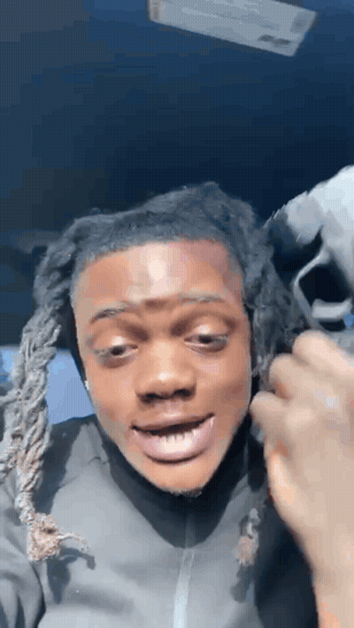 A Man With Dreadlocks Is Making A Funny Face While Sitting In A Car With His Mouth Open . GIF