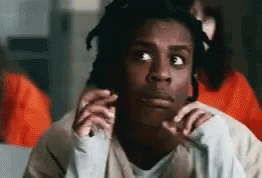 A Man With Dreadlocks Is Making A Funny Face While Sitting In A Cell . GIF