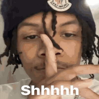 A Man With Dreadlocks Is Making A Shhh Sign With His Finger . GIF