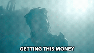 A Man With Dreadlocks Is Singing Into A Microphone With The Words Getting This Money Above Him GIF