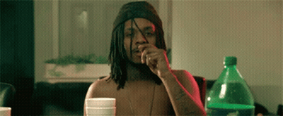 A Man With Dreadlocks Is Sitting At A Table With A Sprite Bottle In Front Of Him GIF