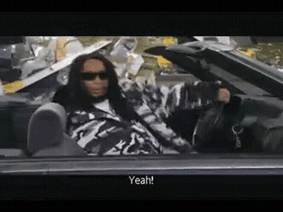 A Man With Dreadlocks Is Sitting In A Convertible Car And Talking . GIF