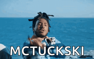 A Man With Dreadlocks Is Standing In Front Of The Ocean And The Words Mctuckski Are Displayed Above Him GIF