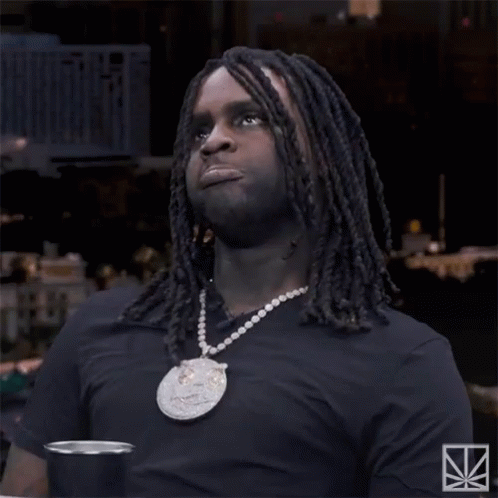 A Man With Dreadlocks Is Wearing A Black Shirt And A Necklace With A Pendant That Says ' N4 ' GIF