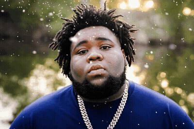 A Man With Dreadlocks Is Wearing A Blue Shirt GIF