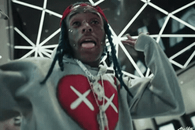 A Man With Dreadlocks Is Wearing A Grey Sweater With A Red Heart On It GIF