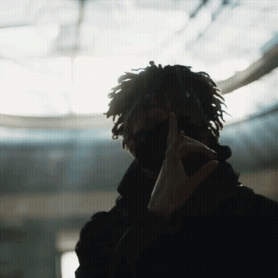 A Man With Dreadlocks Is Wearing A Mask And Making A Peace Sign With His Hands GIF