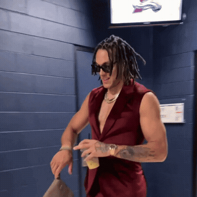 A Man With Dreadlocks Is Wearing A Red Vest GIF