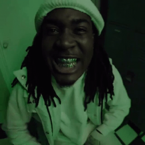 A Man With Dreadlocks Is Wearing A White Hat And A White Jacket And Is Smiling . GIF