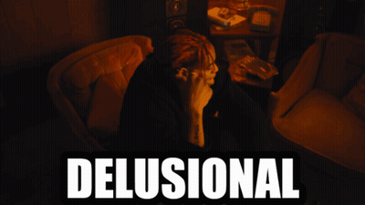 A Man With Dreadlocks Sits In A Chair With The Word Delusional Written Above Him GIF