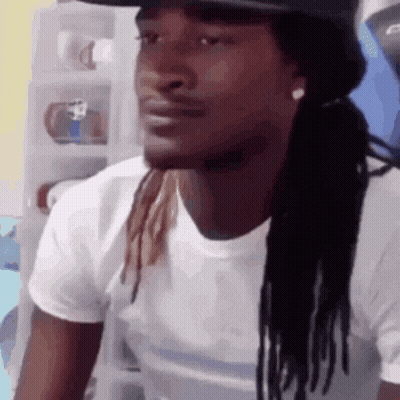 A Man With Dreadlocks Wearing A Hat And A White Shirt GIF