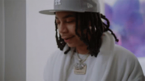 A Man With Dreadlocks Wearing A Hat That Says Ny On It GIF