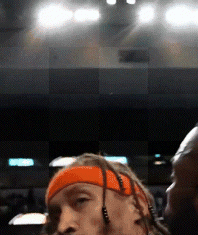 A Man With Dreadlocks Wearing An Orange Headband And Earbuds GIF
