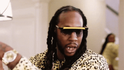 A Man With Dreadlocks Wearing Sunglasses And A Leopard Print Shirt . GIF