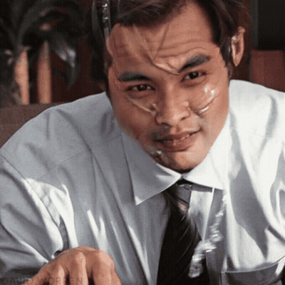 A Man With Duct Tape On His Face Is Sitting At A Desk GIF