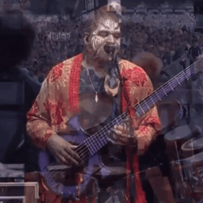 A Man With Face Paint Playing A Bass Guitar GIF