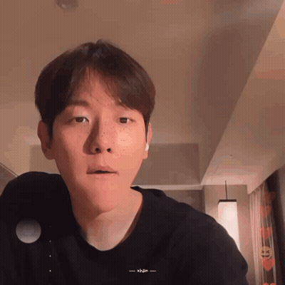 A Man With Freckles On His Face Is Wearing A Black Shirt That Says Xhan On It GIF