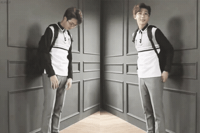 A Man With Glasses And A Backpack Is Standing In A Corner GIF