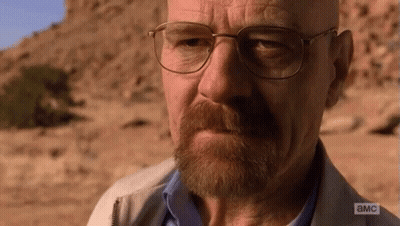 A Man With Glasses And A Beard Is Looking At The Camera With A Cliff In The Background . GIF