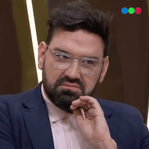 A Man With Glasses And A Beard Is Making A Funny Face GIF