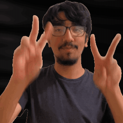 A Man With Glasses And A Beard Is Making A Peace Sign GIF