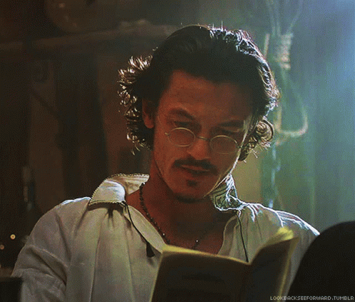 A Man With Glasses And A Beard Is Reading A Book With The Words Lookbackzeeforward.tumblr Below Him GIF