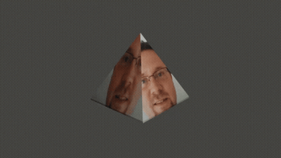A Man With Glasses And A Beard Is Reflected In A Glass Pyramid GIF