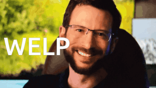 A Man With Glasses And A Beard Is Smiling In Front Of A Screen That Says Welp GIF