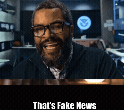 A Man With Glasses And A Beard Is Smiling With The Words That 'S Fake News Above Him GIF