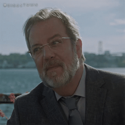 A Man With Glasses And A Beard Is Standing In Front Of A Body Of Water With The Hashtag #Diggstown GIF