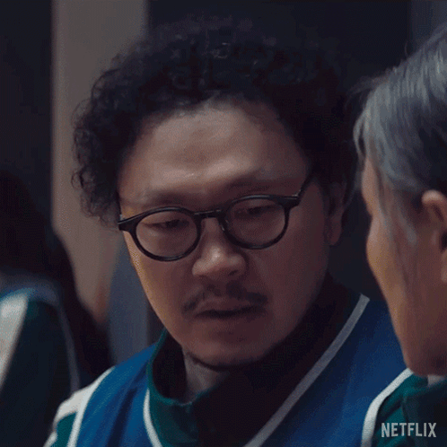 A Man With Glasses And A Beard Is Talking To A Woman In A Netflix Ad . GIF